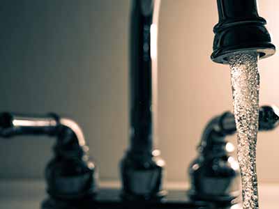 close up photo of a running tap with water pouring out